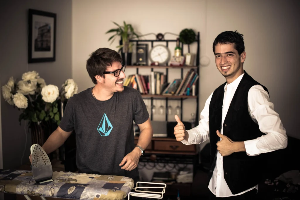The groom shares a cheerful moment with a friend while getting ready.