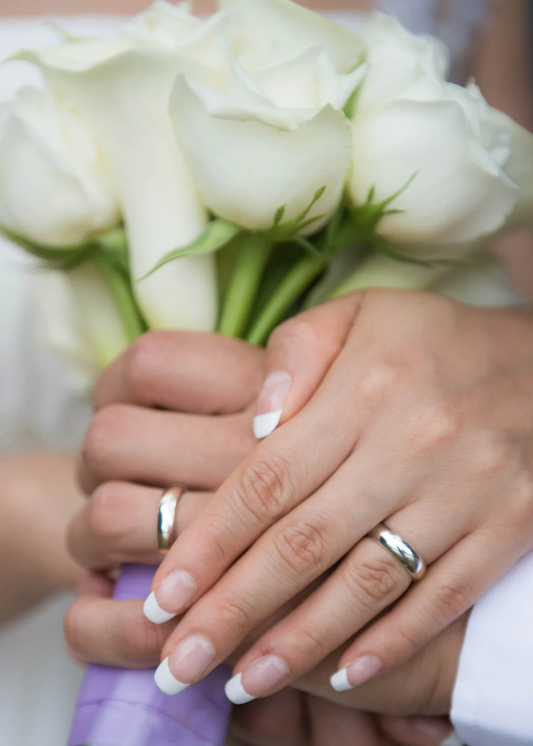 A close-up of the couple’s hands and wedding rings.
